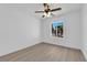 Bedroom featuring a ceiling fan, window with view, light walls, and light wood floors at 6408 Shawnee Pl, Las Vegas, NV 89107