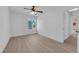 Bedroom featuring a ceiling fan, window, light walls, and light wood floors at 6408 Shawnee Pl, Las Vegas, NV 89107