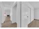 Bright hallway showcasing white walls, doors, and trim, complemented by wood-look flooring and a glimpse of the living room at 6408 Shawnee Pl, Las Vegas, NV 89107