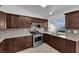 Modern kitchen with stainless steel appliances, granite countertops, and dark wood cabinetry at 6408 Shawnee Pl, Las Vegas, NV 89107