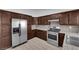 Bright kitchen featuring stainless steel appliances, granite countertops, and dark wood cabinets at 6408 Shawnee Pl, Las Vegas, NV 89107