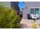 Side yard shows green foliage adjacent to outdoor patio seating and barbecue with privacy wall at 6631 Frosted Harvest Ave, Las Vegas, NV 89108