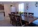 Bright dining area with view into kitchen, decorative wall hangings, table seating for six, and adjacent hallway at 6631 Frosted Harvest Ave, Las Vegas, NV 89108