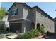 Exterior home elevation showing neutral stucco, tiled roof, desert landscaping, and a two-car attached garage at 6631 Frosted Harvest Ave, Las Vegas, NV 89108