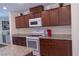 Well-lit kitchen features granite countertops, stainless steel appliances, and plentiful wood cabinets for ample storage at 6631 Frosted Harvest Ave, Las Vegas, NV 89108