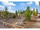 The landscaped backyard features trees, wood chip ground covering, decorative rocks, and fencing at 6907 Kelp Ledge Ct, Las Vegas, NV 89131
