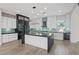 Modern kitchen with sleek white cabinets, blue backsplash, large island and stainless steel appliances at 6907 Kelp Ledge Ct, Las Vegas, NV 89131