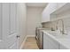 A laundry room is equipped with a stainless steel washer and dryer, and a large sink at 6907 Kelp Ledge Ct, Las Vegas, NV 89131