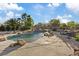 A backyard with a rock waterfall feature leading into the pool, and an outdoor dining set on a patio at 6907 Kelp Ledge Ct, Las Vegas, NV 89131