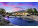 Backyard with a pool featuring custom rock accents and a covered patio under a pink and blue sky at 6907 Kelp Ledge Ct, Las Vegas, NV 89131