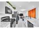 Modern kitchen features stainless steel appliances, granite counters and an adjacent living area at 694 Last Dance Pl, Henderson, NV 89011