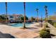 Community pool surrounded by tall palm trees and plush chaise lounge chairs for relaxing at 7701 W Robindale Rd # 206, Las Vegas, NV 89113