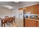 Eat-in kitchen area features wood table and cabinetry, as well as stainless steel refrigerator and countertops at 7701 W Robindale Rd # 206, Las Vegas, NV 89113