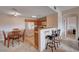 Bright kitchen and dining area with wooden table, bar stools, and appliances, promoting a cozy atmosphere at 7701 W Robindale Rd # 206, Las Vegas, NV 89113