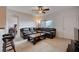 Cozy living room features a comfortable leather sectional, ceiling fan, and natural light from large window at 7701 W Robindale Rd # 206, Las Vegas, NV 89113