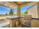 Outdoor kitchen with a built-in grill and prep area for entertaining guests at 7720 Fruit Dove St, North Las Vegas, NV 89084