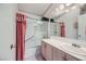 The bathroom features a shower and tub combination with a glass enclosure and pink floral accents at 7900 Ryandale Cir # 201, Las Vegas, NV 89145