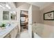 Bathroom featuring double sinks, a separate tub, and access to the main bedroom at 7900 Ryandale Cir # 201, Las Vegas, NV 89145