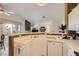 Bright kitchen with white cabinets and tile counters, connecting to a living area with vaulted ceilings at 7900 Ryandale Cir # 201, Las Vegas, NV 89145