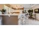 Open kitchen with counter seating, white cabinetry, and a view into the dining area at 7900 Ryandale Cir # 201, Las Vegas, NV 89145