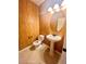 Half bathroom featuring a pedestal sink, toilet, decorative wallpaper, and tiled floor at 81 Sertata Ct, Henderson, NV 89074