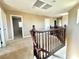 Upstairs hallway with carpet and wood railing featuring multiple doors and overhead lighting at 81 Sertata Ct, Henderson, NV 89074