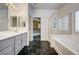 Bathroom with dual vanity sinks, a separate shower, and a soaking tub, providing a luxurious experience at 900 Royal Plum Ln, Las Vegas, NV 89144