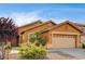 Charming single-story home with a two-car garage, desert landscaping, and a terracotta-colored exterior at 900 Royal Plum Ln, Las Vegas, NV 89144