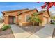 Attractive single-story home featuring a terracotta-colored exterior, arched entrance, and a well-maintained front yard at 900 Royal Plum Ln, Las Vegas, NV 89144
