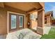 Inviting covered patio with columns, French doors, artificial grass, and stucco exterior at 900 Royal Plum Ln, Las Vegas, NV 89144