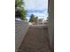 Backyard with gravel, brick wall, and trees in the background, offering a low-maintenance outdoor space at 1144 Black Cherry St, Las Vegas, NV 89142