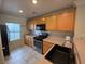 Well-lit kitchen featuring wood cabinets, tile backsplash, modern appliances, and granite countertops at 1144 Black Cherry St, Las Vegas, NV 89142