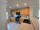 Well-lit kitchen featuring wooden cabinets, laminate countertops, and modern stainless steel appliances at 1144 Black Cherry St, Las Vegas, NV 89142