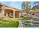 Backyard features an inviting covered patio, manicured lawn, and a custom rock-lined pond with water feature at 1234 Campbell Dr, Las Vegas, NV 89102