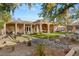 Expansive backyard featuring a covered patio, lush green lawn, mature landscaping, and a tranquil rock garden at 1234 Campbell Dr, Las Vegas, NV 89102