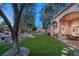 Picturesque backyard with a rock waterfall feature, lush lawn, and covered patio for outdoor living at 1234 Campbell Dr, Las Vegas, NV 89102