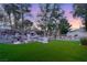 Secluded backyard featuring a custom rock waterfall, lush green grass, and mature landscaping at 1234 Campbell Dr, Las Vegas, NV 89102