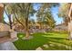 Landscaped backyard featuring lush greenery, a stone waterfall, and an outdoor kitchen area, perfect for relaxation at 1234 Campbell Dr, Las Vegas, NV 89102