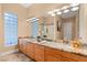 Spacious bathroom with a large mirror, marble countertops, double sinks, and unique lighting fixtures and glass block window at 1234 Campbell Dr, Las Vegas, NV 89102
