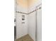 Clean bathroom shower featuring white tile, mosaic accents, and built-in shelves, with a shower door at 1234 Campbell Dr, Las Vegas, NV 89102