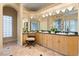Spacious main bathroom featuring dual sinks, vanity area, glass block window, and custom cabinetry at 1234 Campbell Dr, Las Vegas, NV 89102