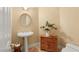 Charming powder room with pedestal sink, decorative mirror, and rustic wooden cabinet at 1234 Campbell Dr, Las Vegas, NV 89102