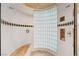 Modern walk-in shower with curved glass block wall, dual shower heads, and custom tile accents at 1234 Campbell Dr, Las Vegas, NV 89102