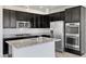 Modern kitchen features stainless steel appliances, granite countertops, and stylish dark cabinets at 12524 Skylight View St, Las Vegas, NV 89138