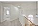 Upper hallway with wood railing, neutral carpet, decorative light, and white walls at 1604 Tamborine Ct, Las Vegas, NV 89128