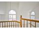 Upper landing with railing overlooking a large arched window and a decorative light fixture at 1604 Tamborine Ct, Las Vegas, NV 89128
