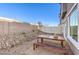 Backyard features a gravel area and wood table with bench seating, perfect for outdoor dining at 216 Biscotti Ave # Lot 126, North Las Vegas, NV 89084