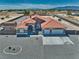 An aerial view of the property featuring a three-car garage, a clay tile roof, and gravel landscaping at 2171 Deadwood St, Pahrump, NV 89048