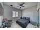 Well-lit bedroom with a ceiling fan, a window with blinds, and wood-look floors at 2171 Deadwood St, Pahrump, NV 89048
