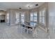 Dining area with an elegant black table and seating for six, with a view through the French doors to the backyard at 2171 Deadwood St, Pahrump, NV 89048